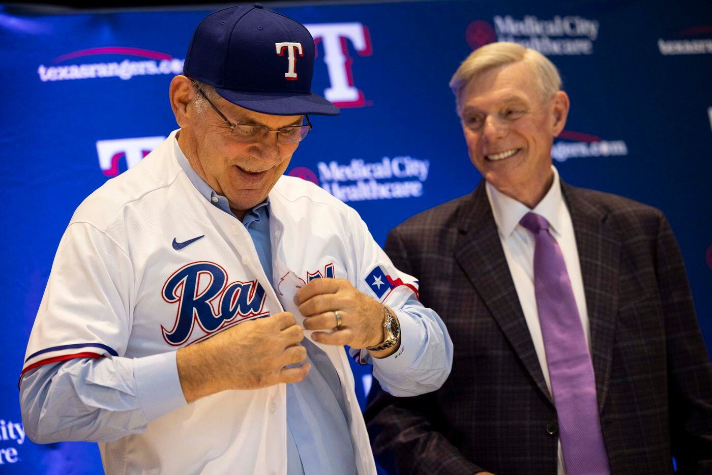 Texas Rangers owner Ray Davis (right) smiles as new Texas Rangers manager Bruce Bochy puts...