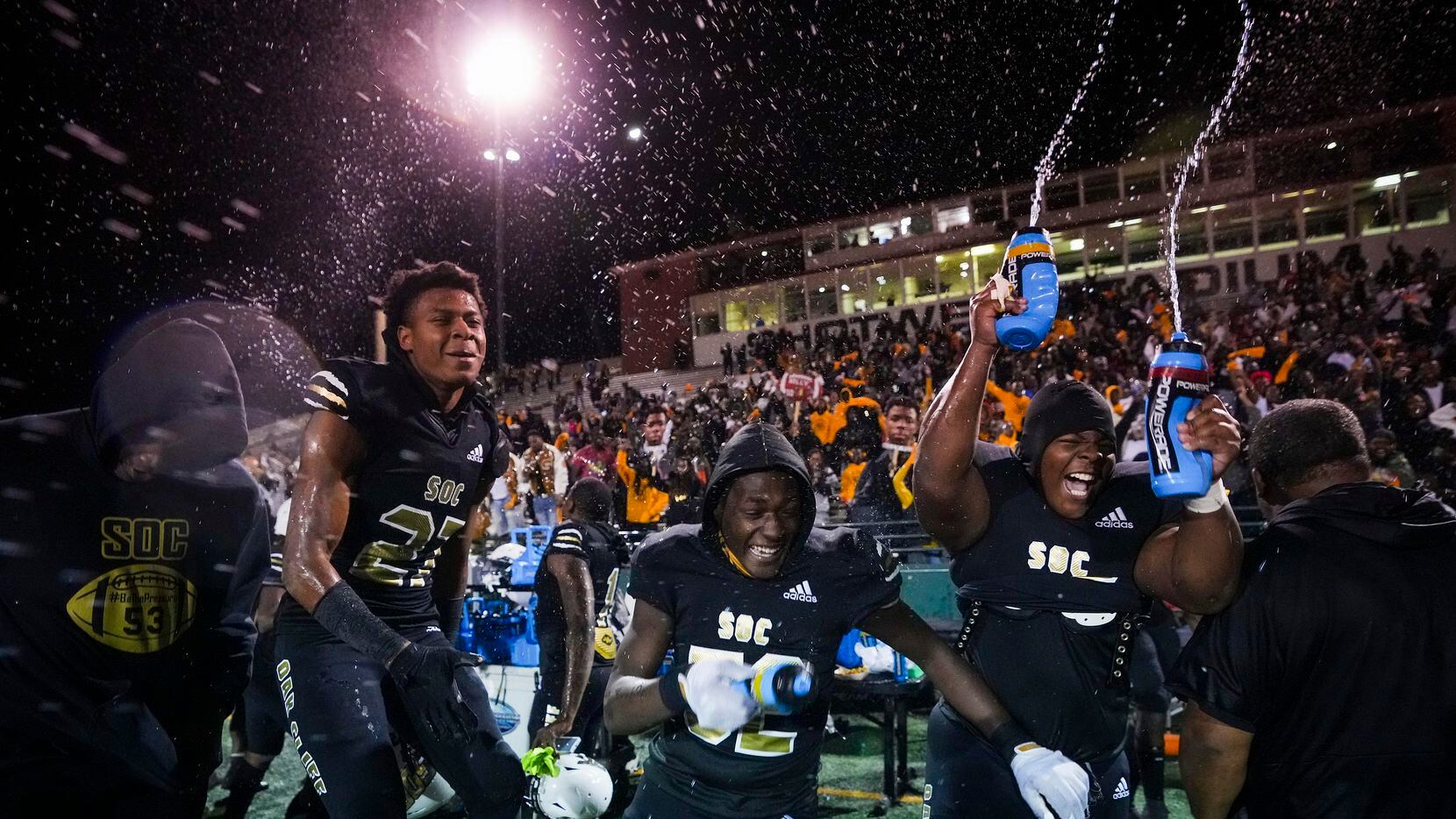 South Oak Cliff players, including defensive back Semaj'dre Gasaway (27) , defensive lineman Kelan Durant (52) and defensive lineman Courtland Kidd (right) celebrate as time expires on a victory over Lubbock Cooper in a Class 5A Division II state semifinal at Shotwell Stadium on Friday, Dec. 10, 2021, in Abilene, Texas. (Smiley N. Pool/The Dallas Morning News)