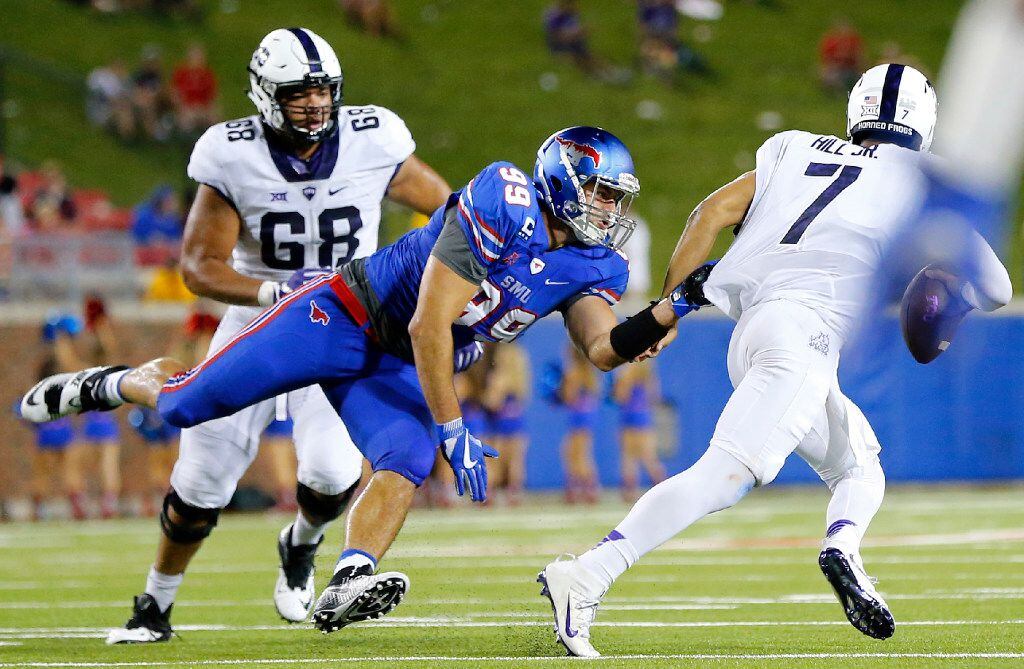 Southern Methodist Mustangs defensive end Justin Lawler (99) tries to hang on to TCU Horned...