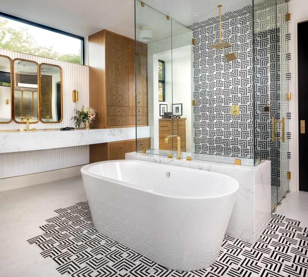 In the master bath, linear pattern tiles extend from the shower walls to the...