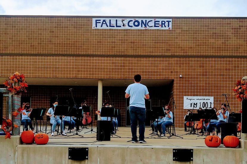 McKinney High School orchestra members perform on the school's loading dock during a concert...