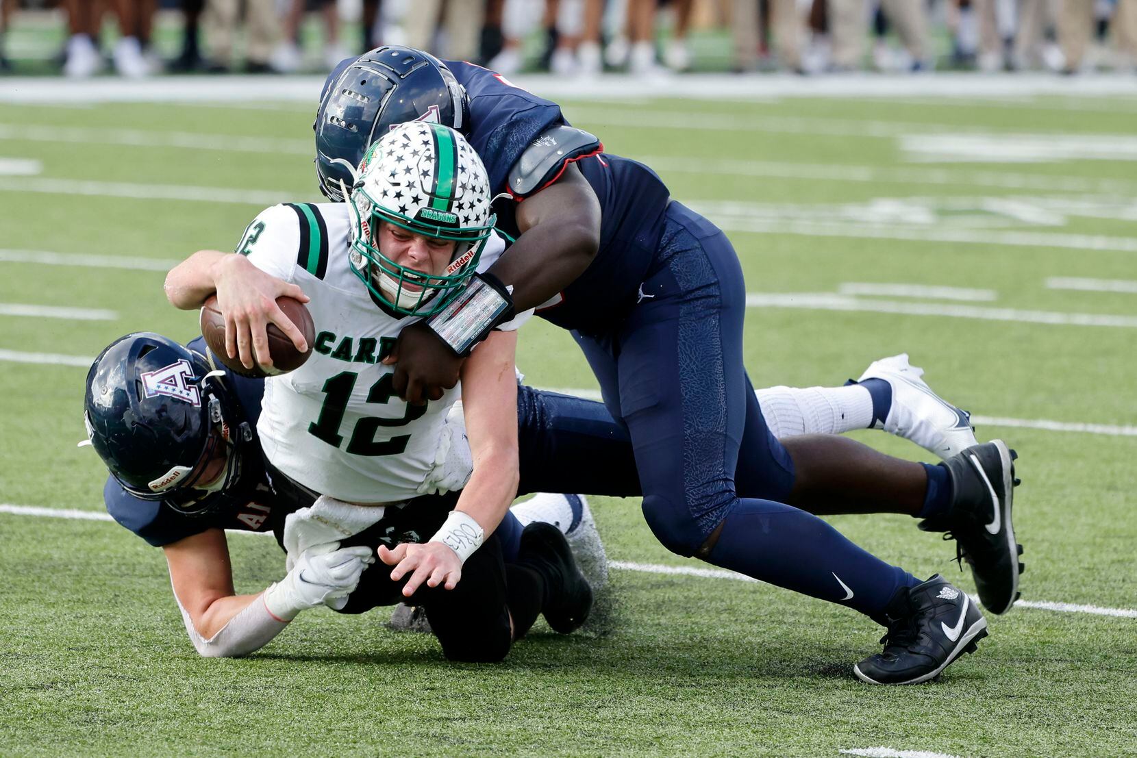 Allen’s Aidan Graham, left, and DJ Hicks, top, tackle Southlake quarterback Kaden Anderson (12) during the first half of a Class 6A Division I Region I final high school football game in Denton, Texas on Saturday, Dec. 4, 2021. (Michael Ainsworth/Special Contributor)