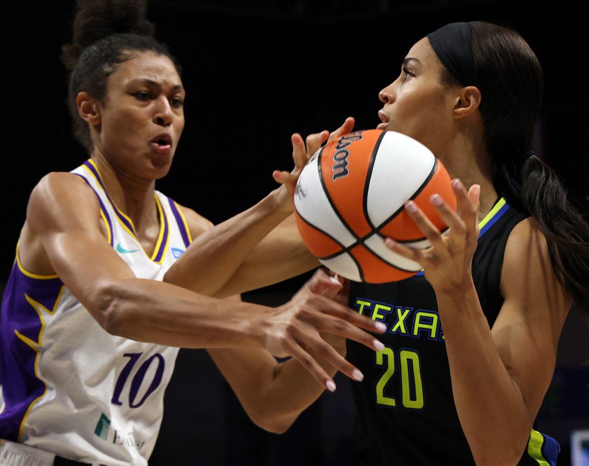 Dallas wings forward Isabelle Harrison (20) looks to pass against the defensive pressure of...