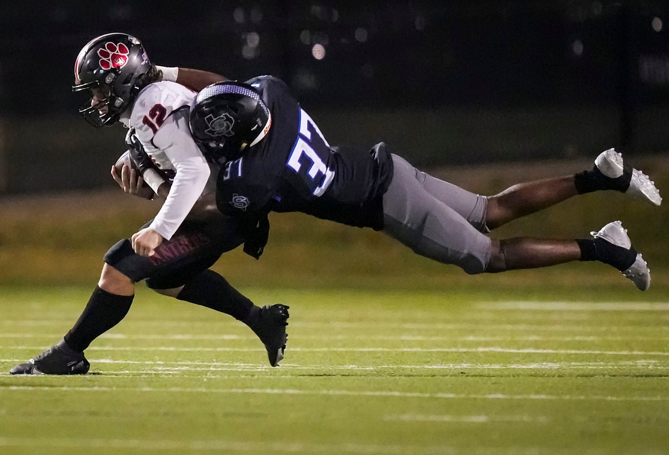 Colleyville Heritage quarterback Luke Ullrich (12) is brought down by Mansfield Summit linebacker Jaden Williams (37) during the second half of the Class 5A Division I Region I final on Friday, Dec. 3, 2021, in North Richland Hills, Texas. (Smiley N. Pool/The Dallas Morning News)