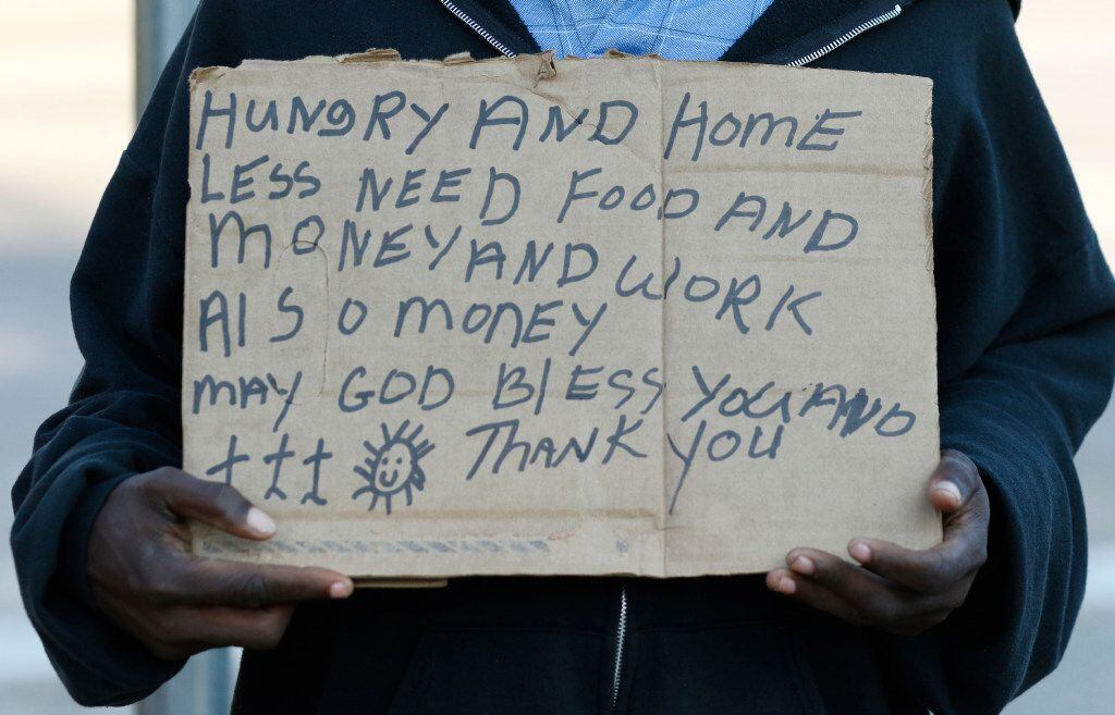 Larry Harris, 51, and homeless, panhandles at the intersection I-35E and Market Center in...