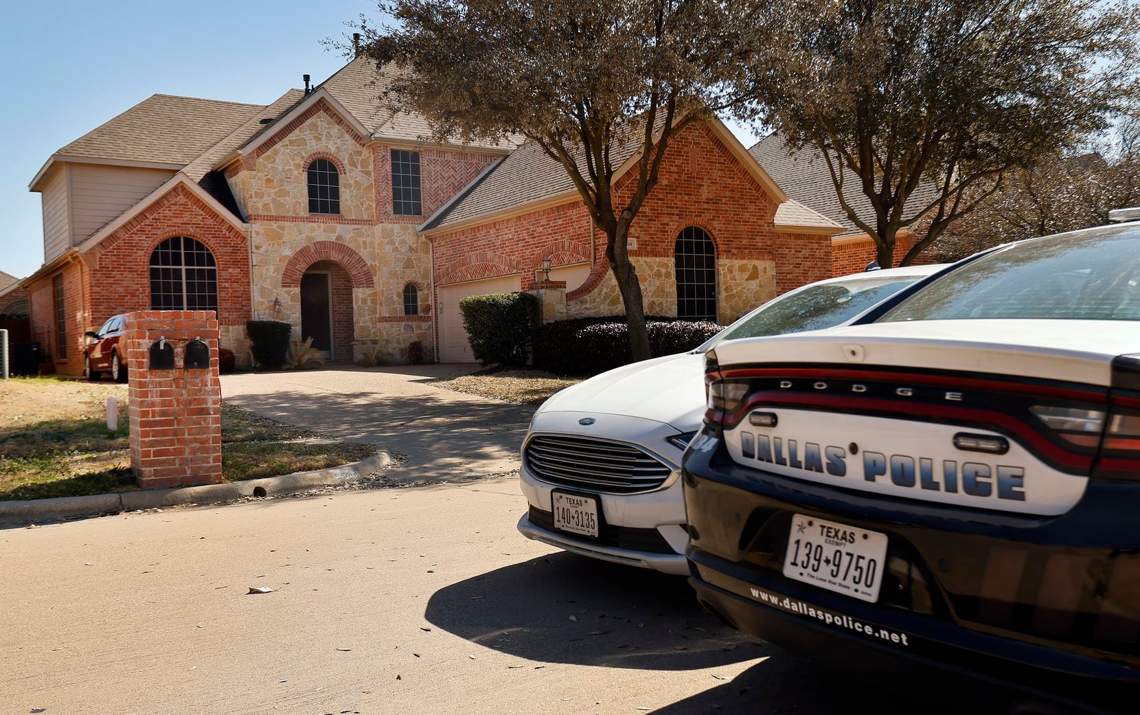 A pair of Dallas olice cars were parked outside the home of Dallas officer Bryan Riser in south Grand Prairie on Thursday.