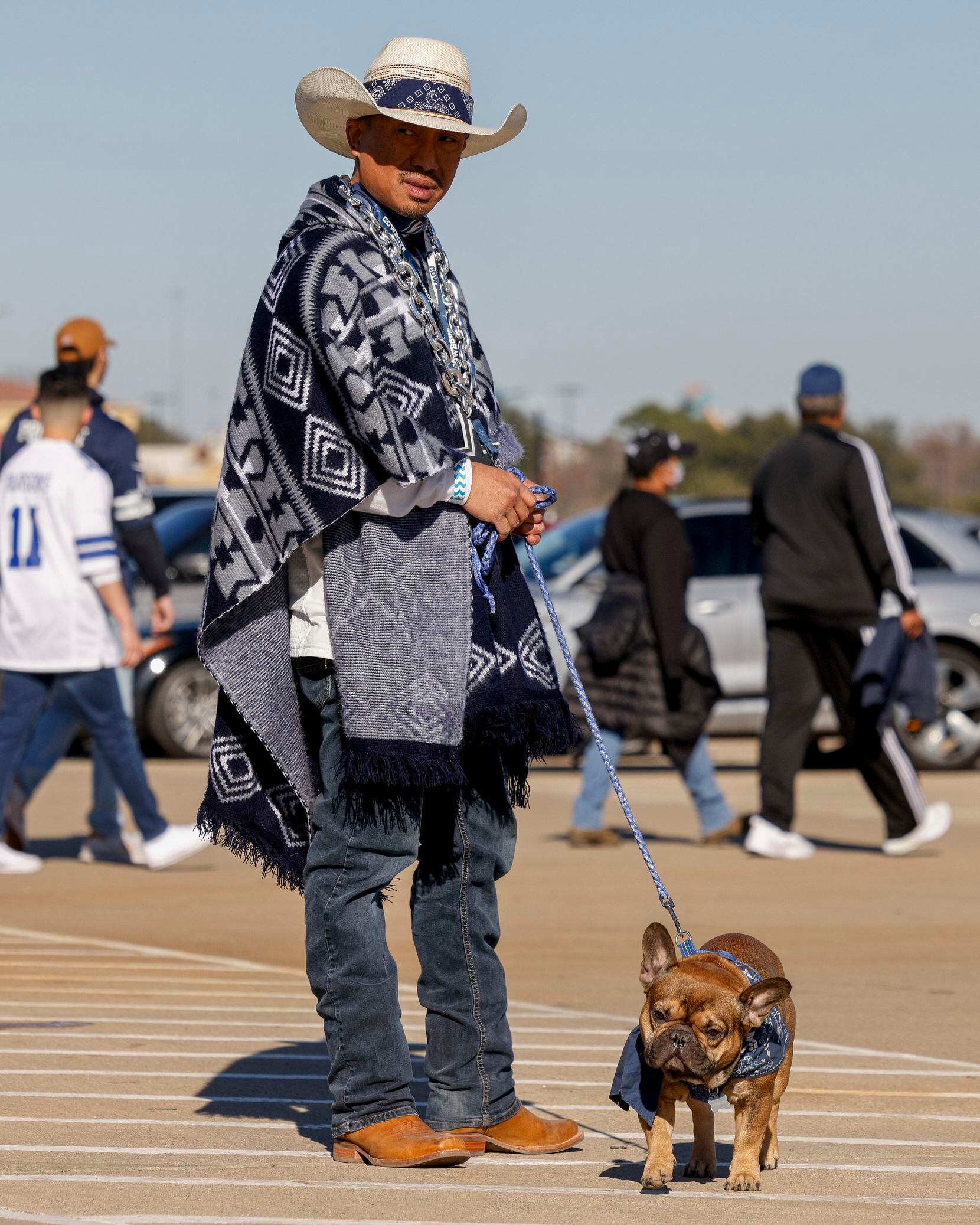 Wanhdee Vongkaeo walks his dog Winston before an NFL wild-card playoff game between the...