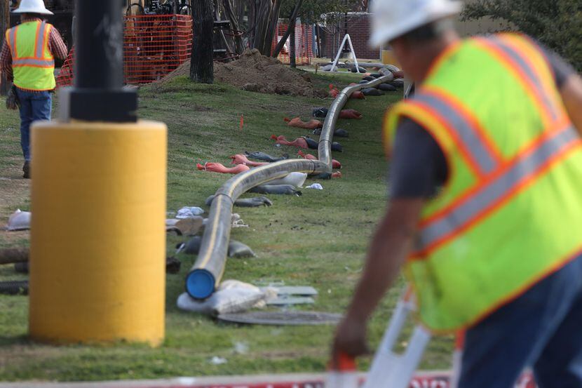 Un grupo de trabajadores instala tuberías de gas en Midway Road el año pasado. LOUIS...