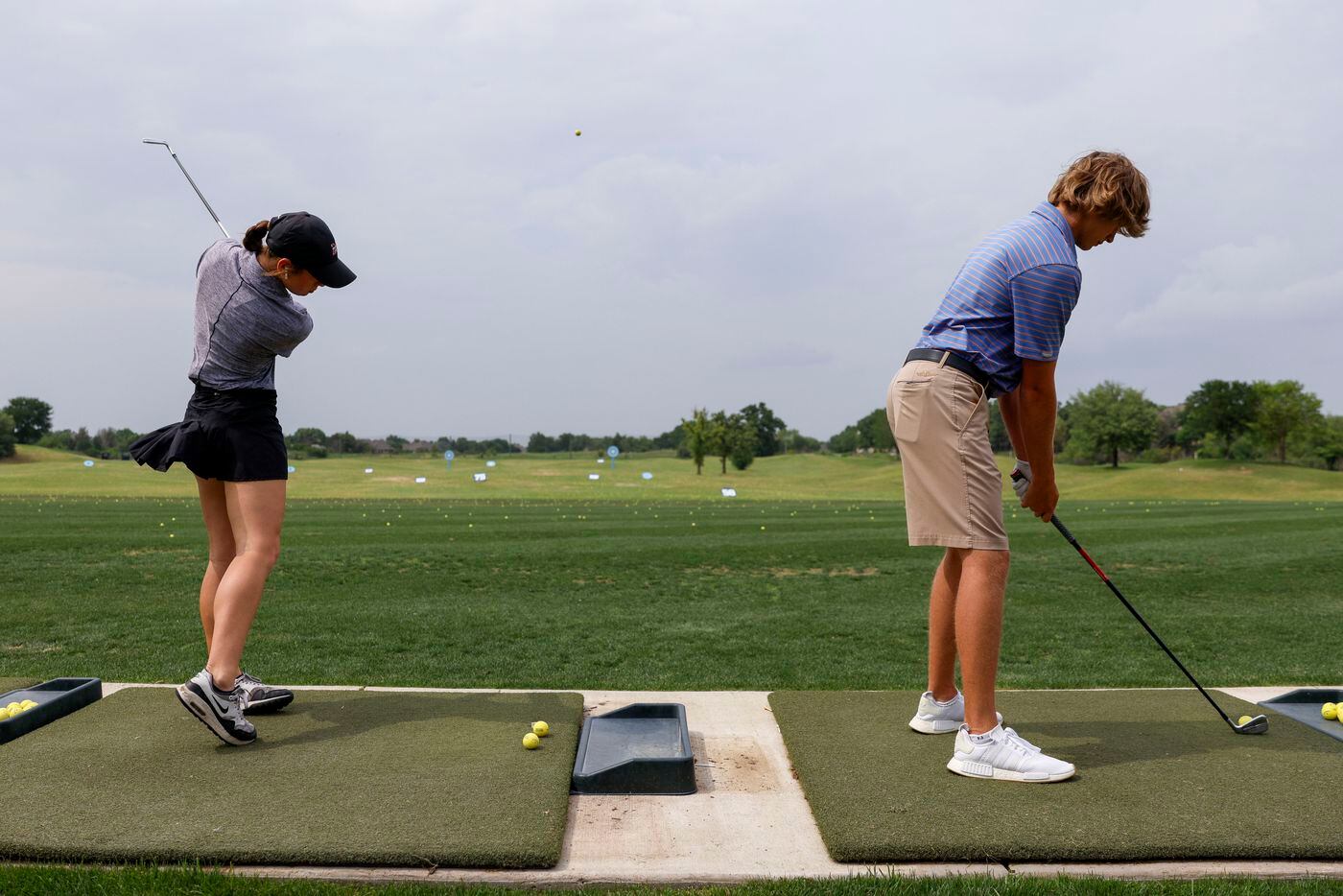 Marcus golfers Kamri Gabel (left) and Sam Pampling practice their swings on the driving...