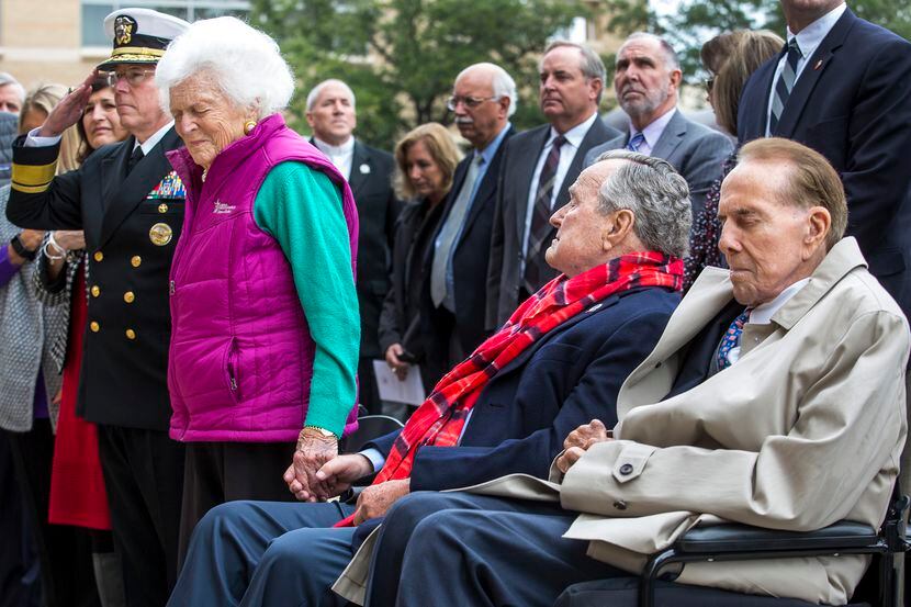 2016: Barbara Bush stands beside former President George H.W. Bush (seated) and former Sen....