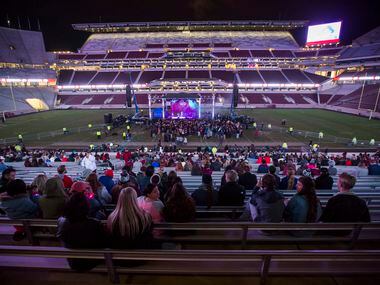 People gather to watch the Bill Clark Trio perform during the Aggies United event at Kyle...