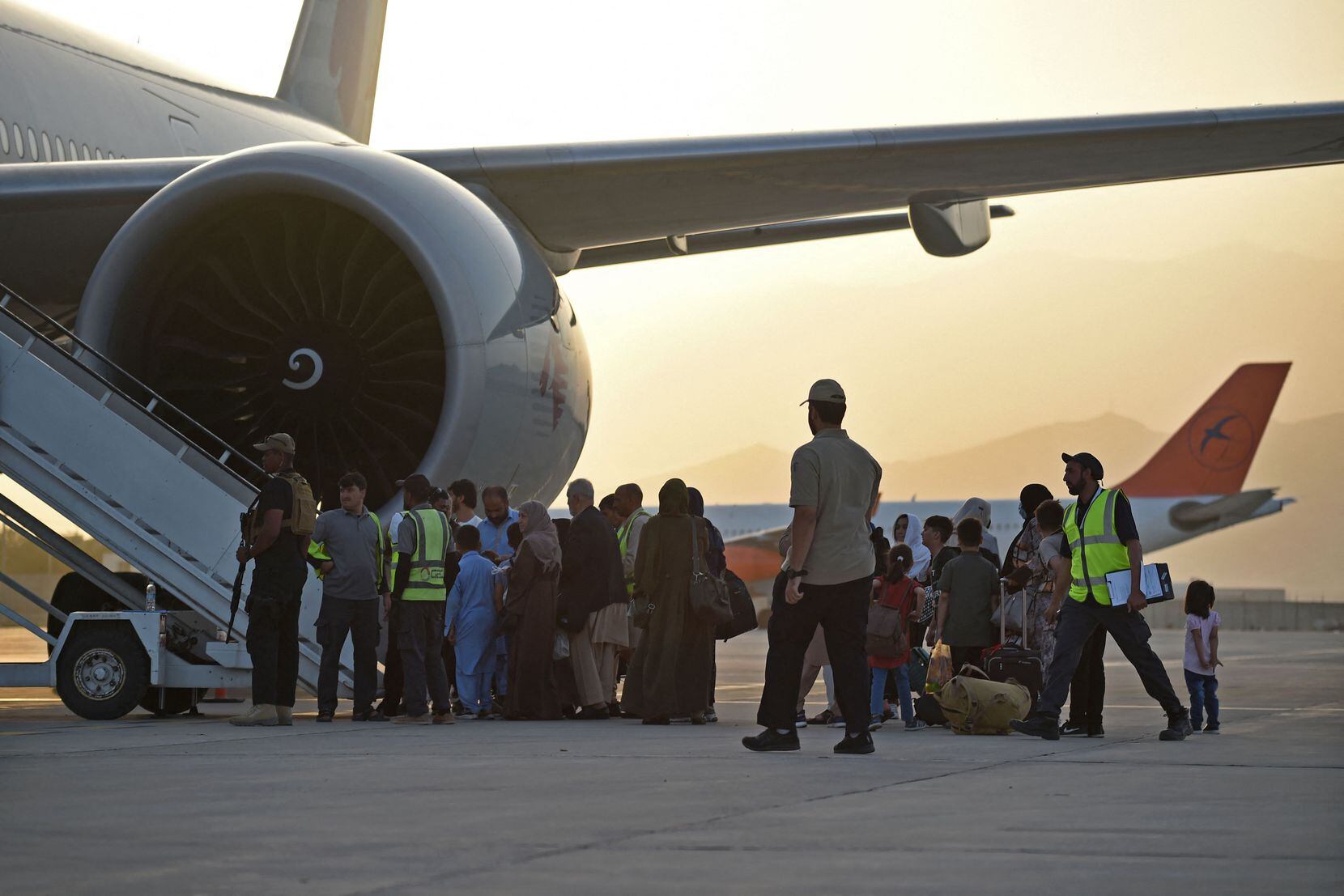 Passengers prepare to board a Qatar Airways aircraft at the airport in Kabul on September 9,...