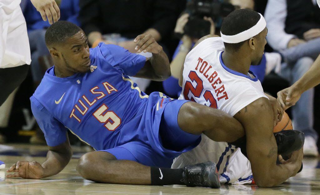 
Tulsa guard Rashad Ray (5) gets his foot tangled with SMU forward Jordan Tolbert (23)...