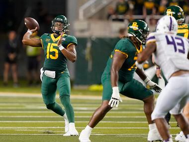 Baylor quarterback Kyron Drones (15) throws a pass with blocking from offensive lineman...