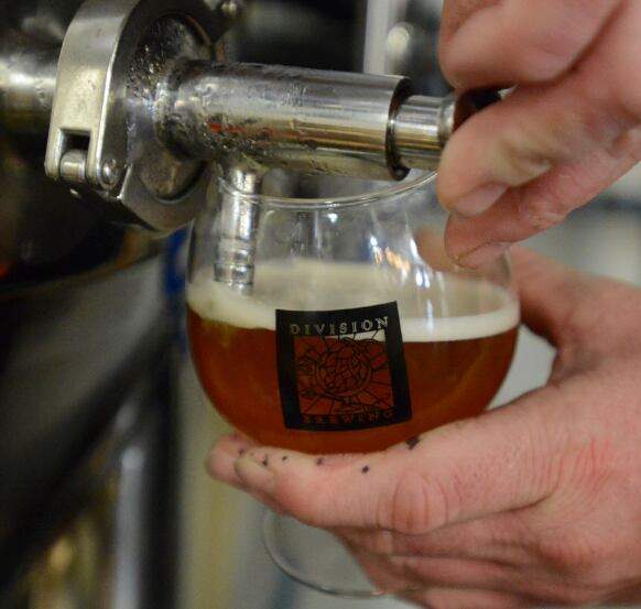 A bartender draws one of Division Brewing’s IPAs for a customer on Saturday March 5, 2016 in...