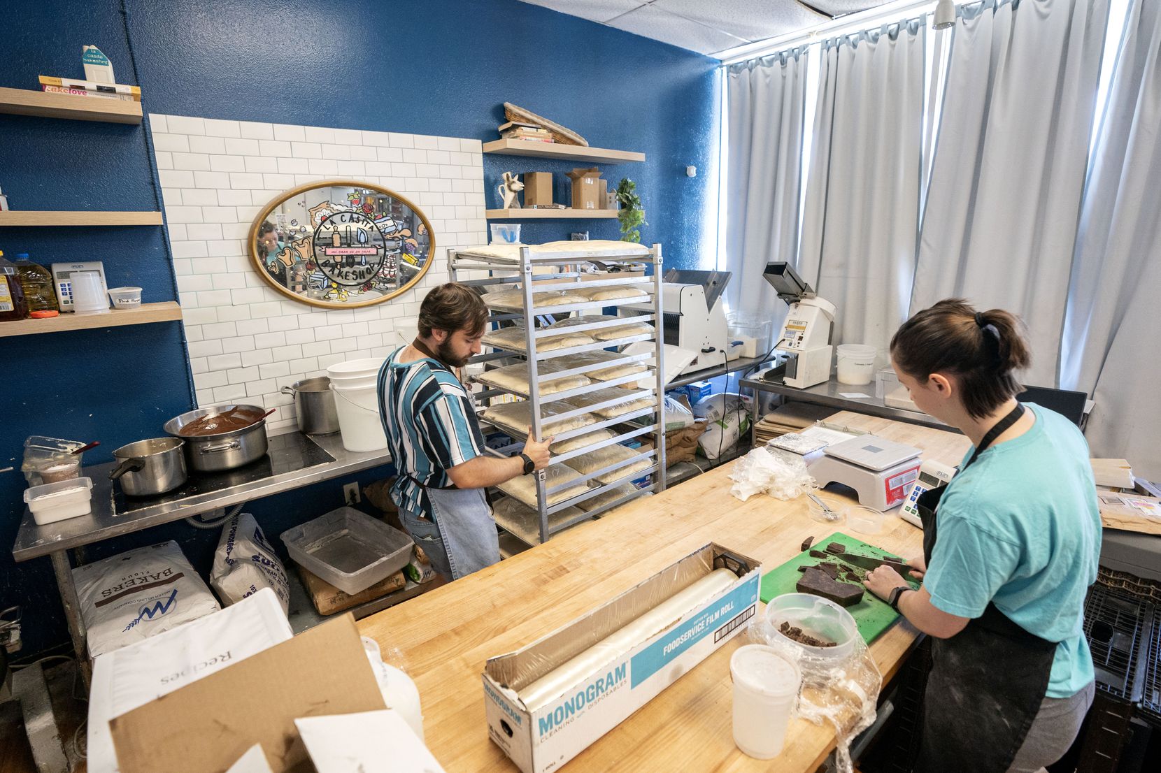 Tom Cedeño, left, moves dough to the freezer while sous chef Jessica Shaw cuts chocolate at...