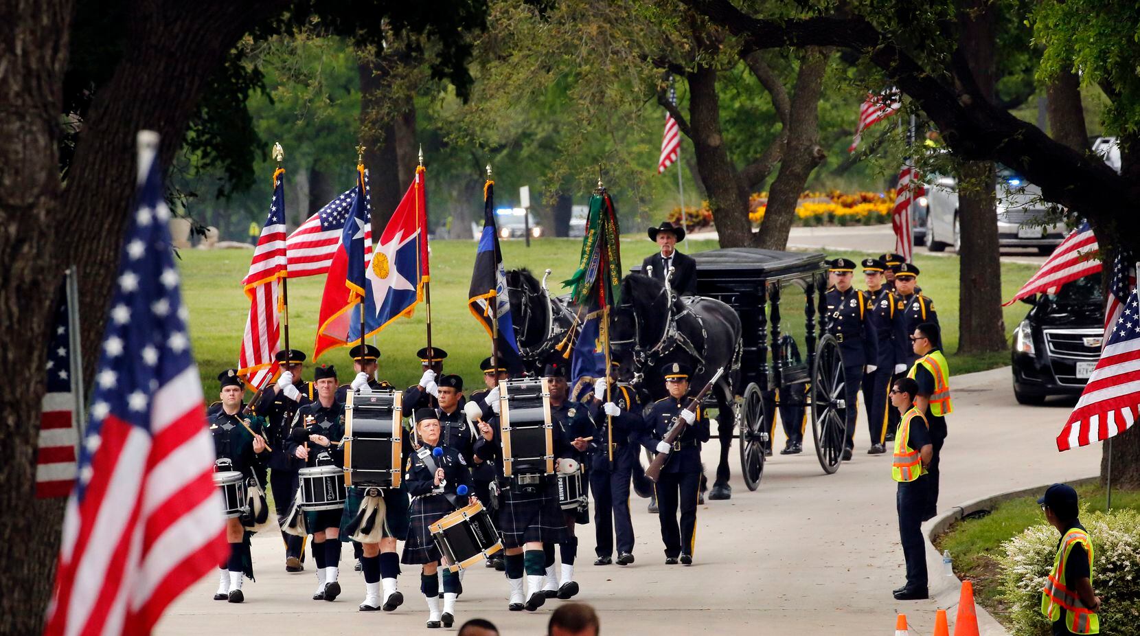 The Dallas Police Color Guard and Honor Guard escort the horse-drawn carriage carrying slain...