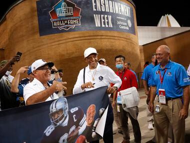 Pro Football Hall of Fame inductee Drew Pearson of the Dallas Cowboys (center) poses for...