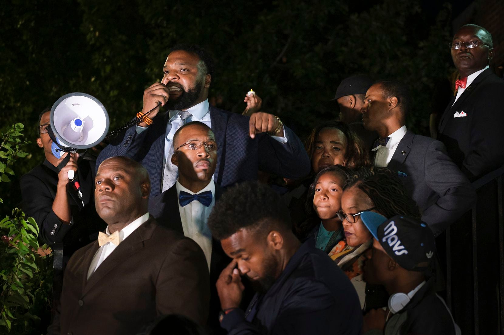 Attorney Lee Merritt stands with members of the victimÕs family as he addresses a community...