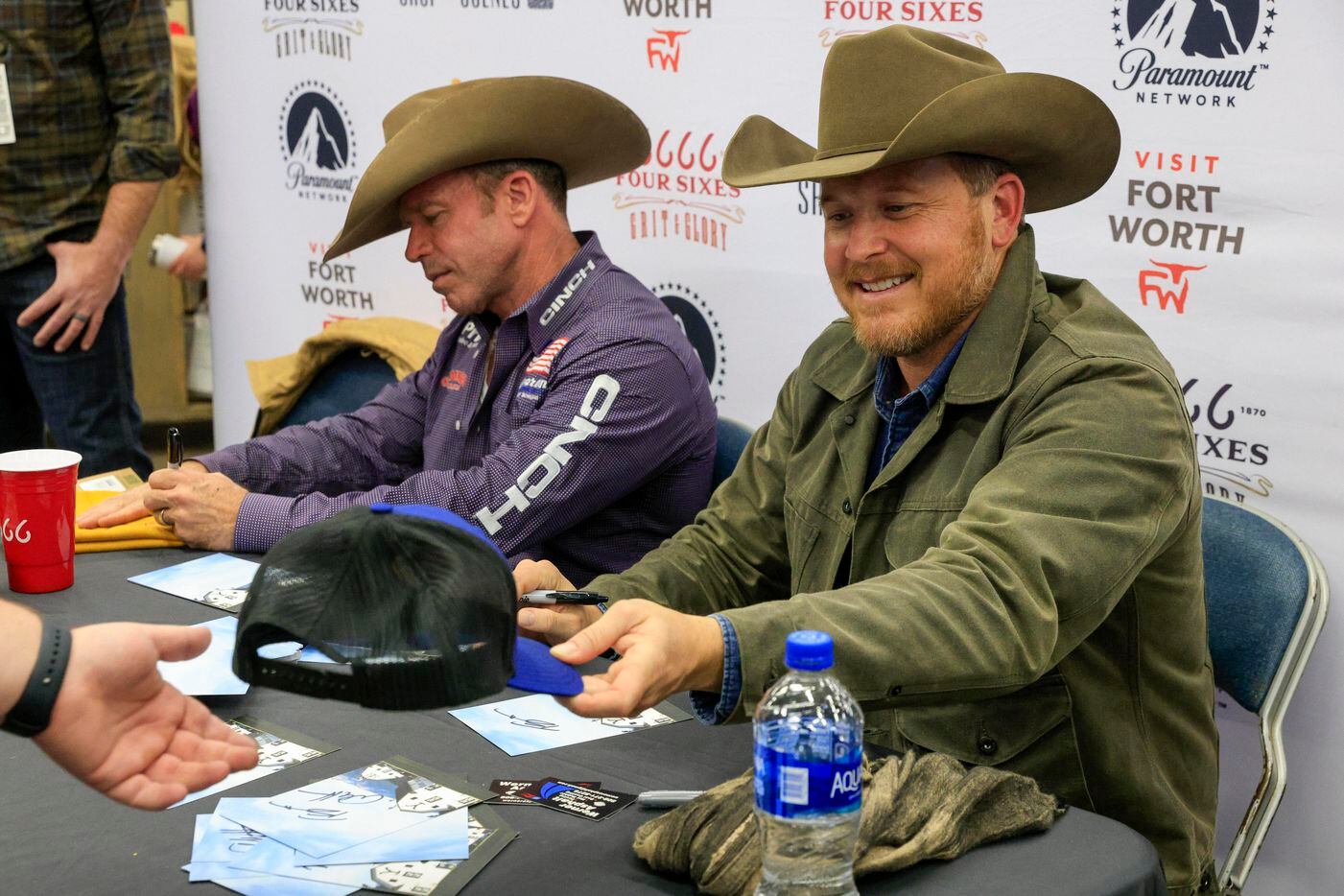 “Yellowstone” creator Taylor Sheridan (left) and actor Cole Hauser sign autographs for fans...