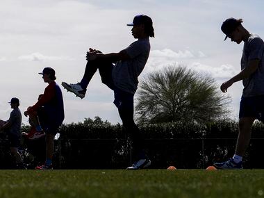 Players stretch on a conditioning field during the Texas Rangers first minor league spring...