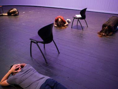 Cast members lay on the floor while practicing the opening scene of Shots Fired.