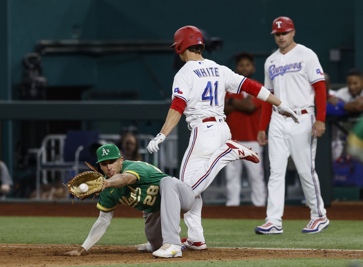 Texas Rangers’ Eli White (41) is safe at first as Oakland Athletics first baseman Matt Olson...
