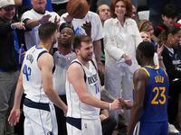 Dallas Mavericks guard Luka Doncic (77) shakes hands with Golden State Warriors forward...
