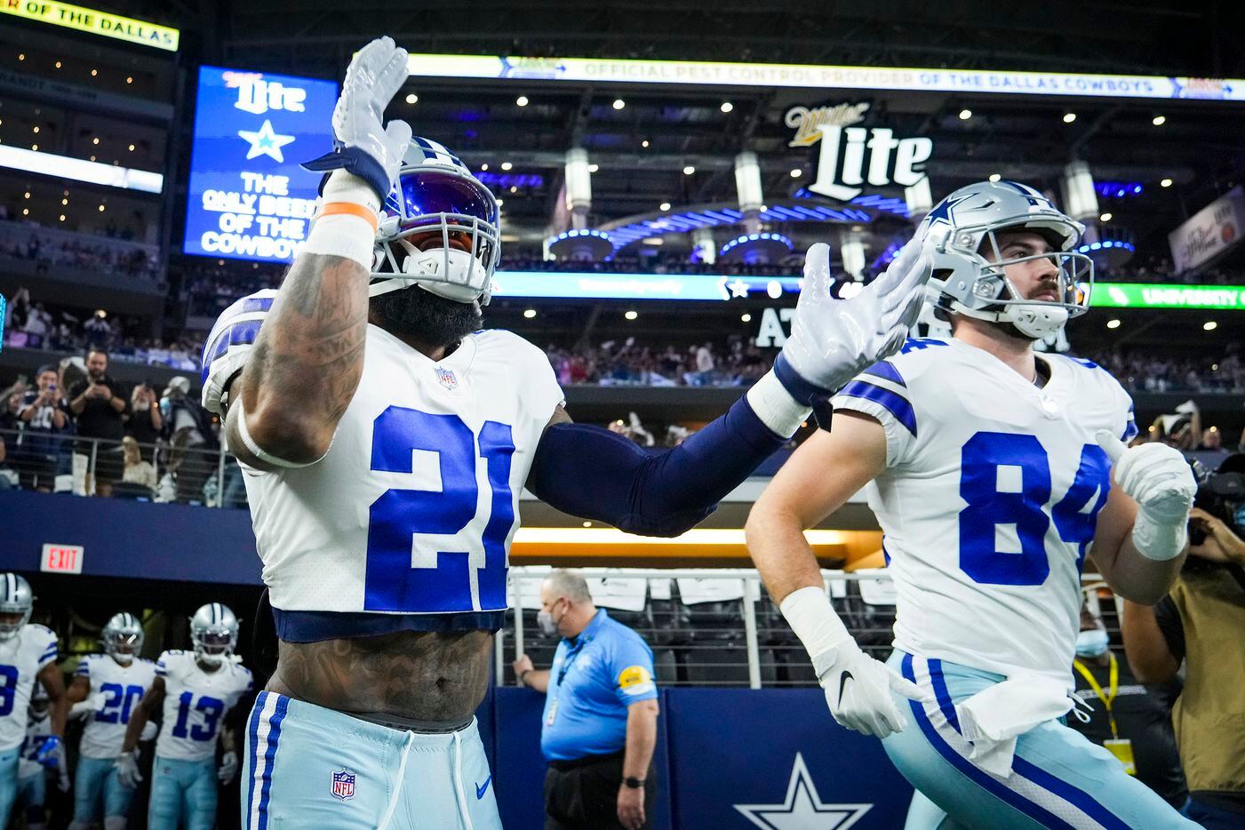 Dallas Cowboys running back Ezekiel Elliott (21) abd tight end Sean McKeon (84) take the field to warm up before an NFL football game against the Washington Football Team at AT&T Stadium on Sunday, Dec. 26, 2021, in Arlington.