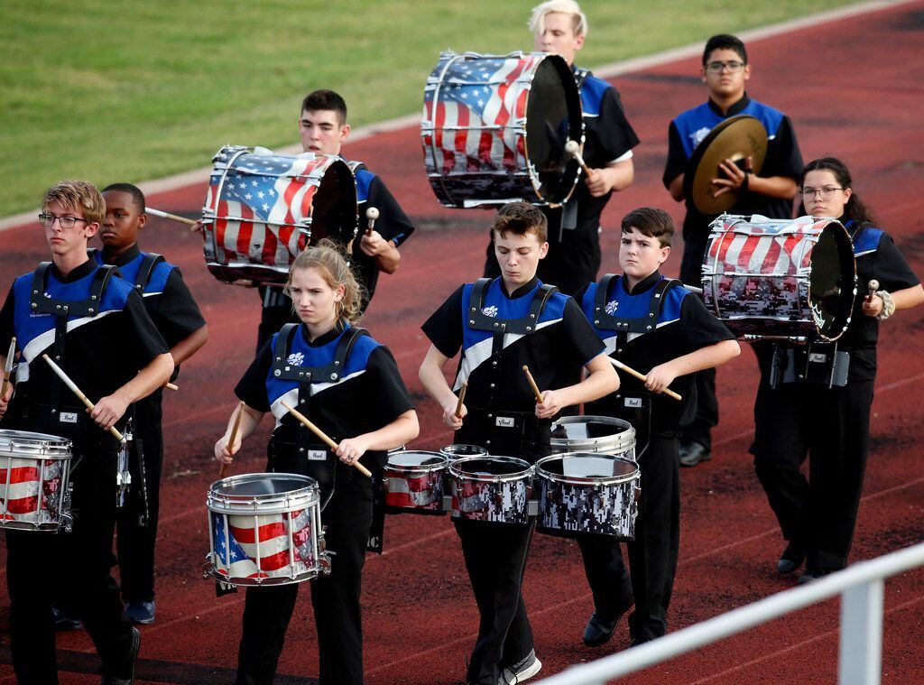 Members of the Trinity Christian Cedar Hill drum corps march along the track prior to the...