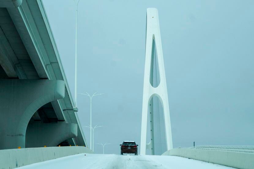 Un carro avanza sobre una superficie de hielo en una rampa al Margaret McDermott Bridge de...