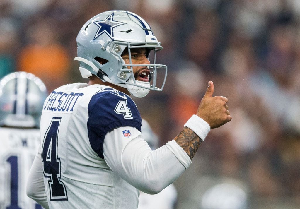 Cowboys quarterback Dak Prescott (4) gives a thumbs up during the third quarter of a game...