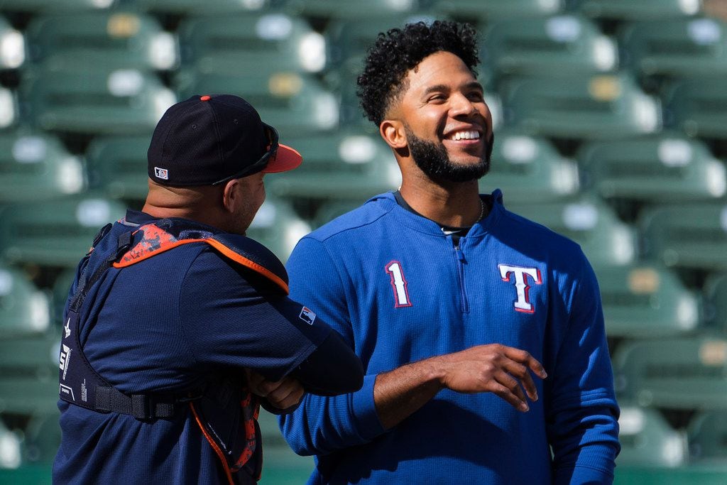 Texas Rangers shortstop Elvis Andrus laughs with Houston Astros bullpen catcher Javier...
