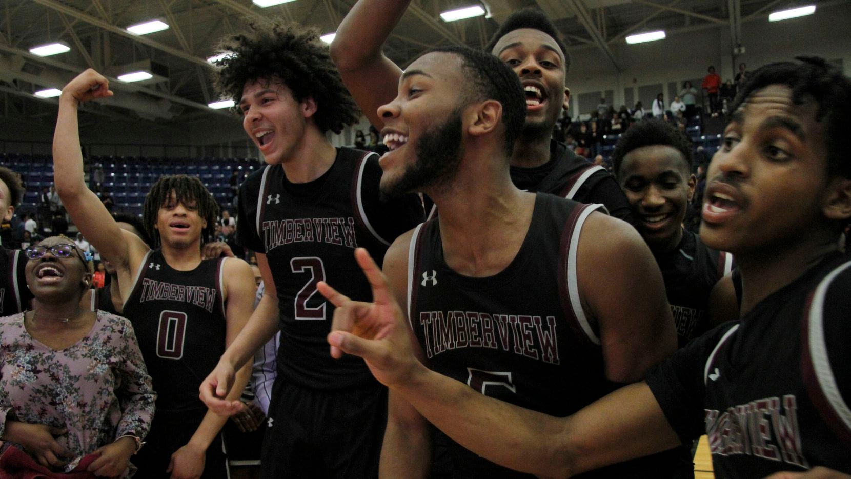 Members of the Mansfield Timberview varsity boys basketball team assemble at mid-court in...