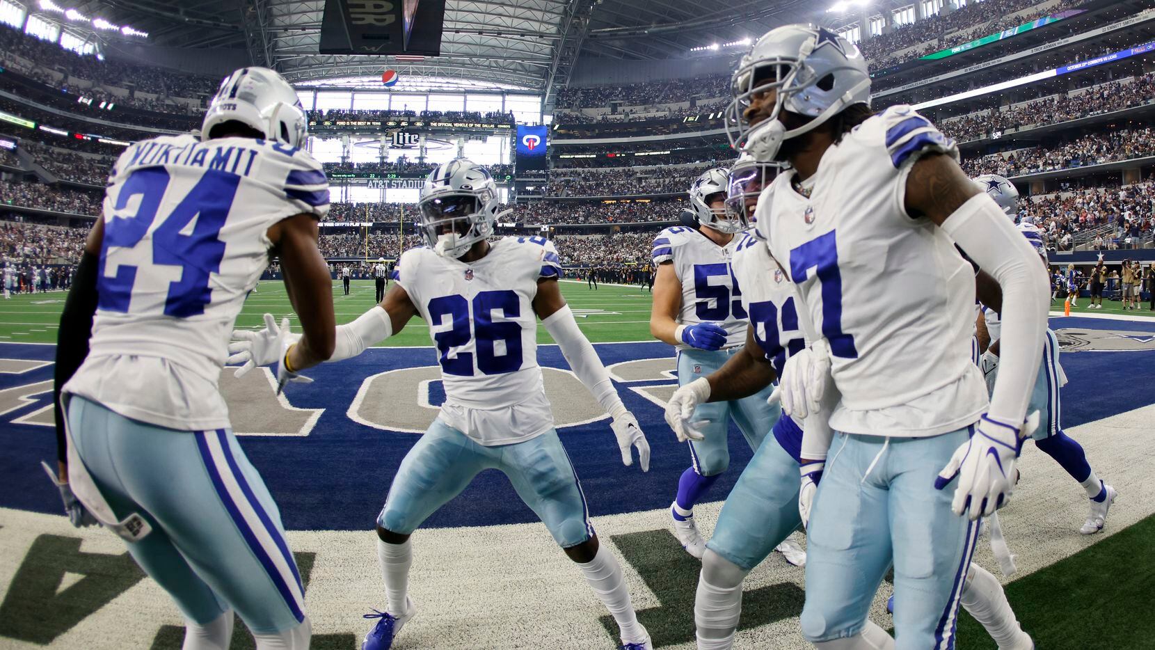 Dallas Cowboys' Israel Mukuamu (24), Trevon Diggs (7) and others celebrate with cornerback...