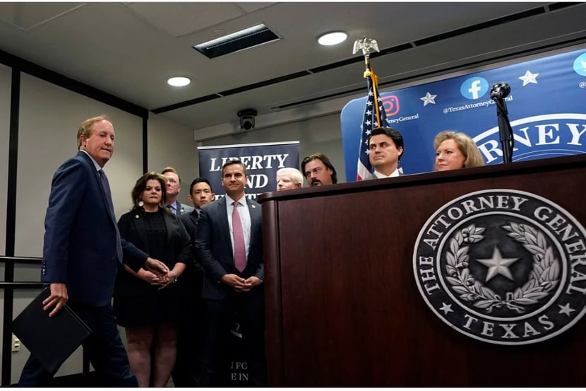 El fiscal general del estado de Texas, Ken Paxton, a la izquierda, llega con su personal...