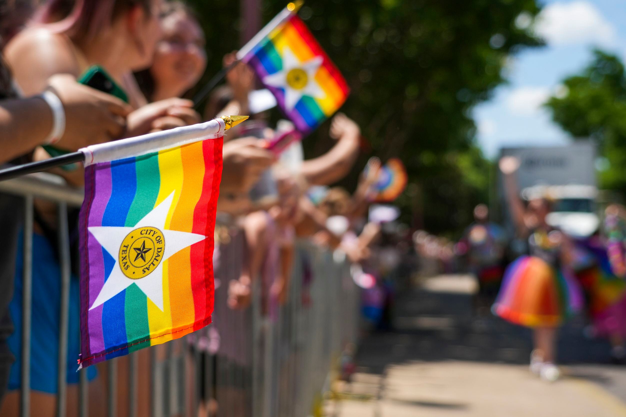 Spectator wave City of Dallas Pride flags during the annual Alan Ross Texas Freedom Parade...