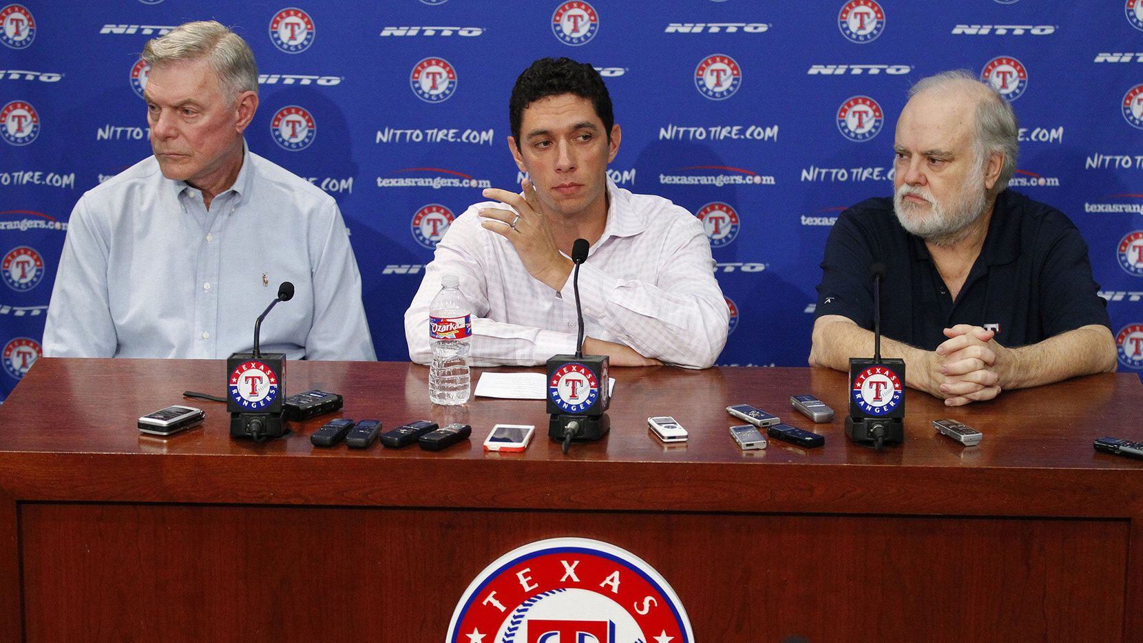 Texas Rangers owners Ray Davis, left, and Bob Simpson, right, flank President of Baseball Operations and General Manager Jon Daniels at a news conference at Globe Life Park in Arlington, Texas, on Sept. 5, 2014. (Richard W. Rodriguez/Fort Worth Star-Telegram/TNS)