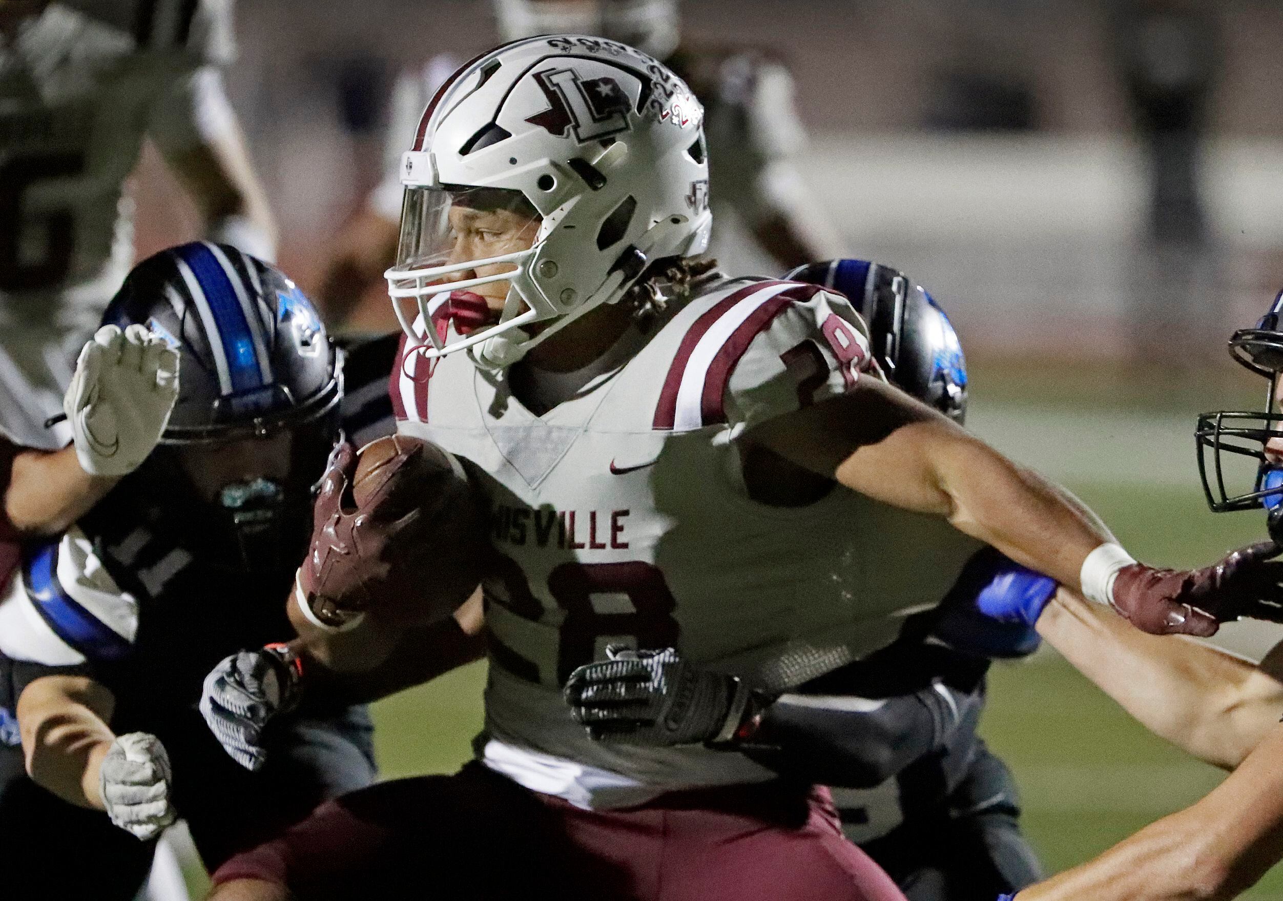Lewisville High School running back Tenel Hill (28) spins into the defense during the first...