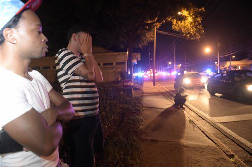 Jermaine Towns (izquierda) y Brandon Shuford observan desde la acera en la misma calle de un...