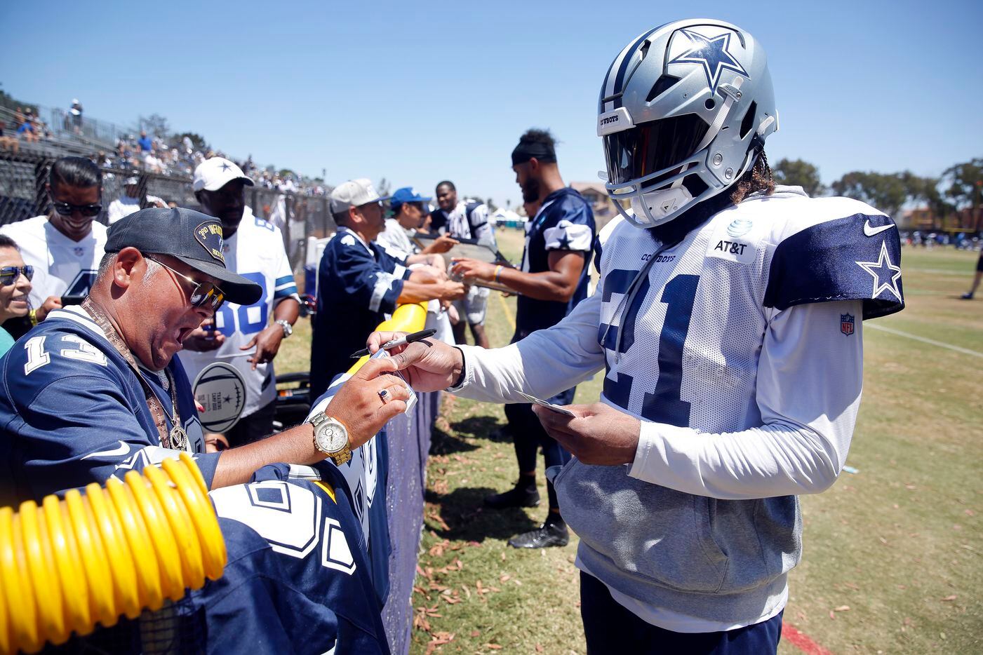 Dallas Cowboys running back Ezekiel Elliott (21) signs autographs for retired Army veteran...