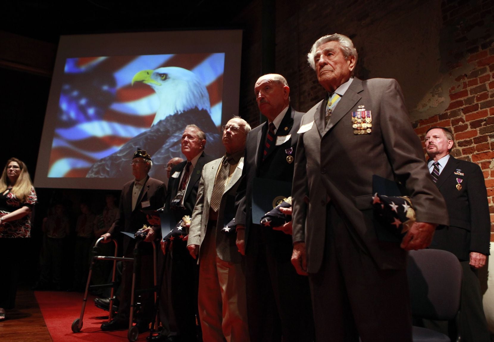 World War ll veteran James Megellas (front right) and other Purple Heart recipients, stand...