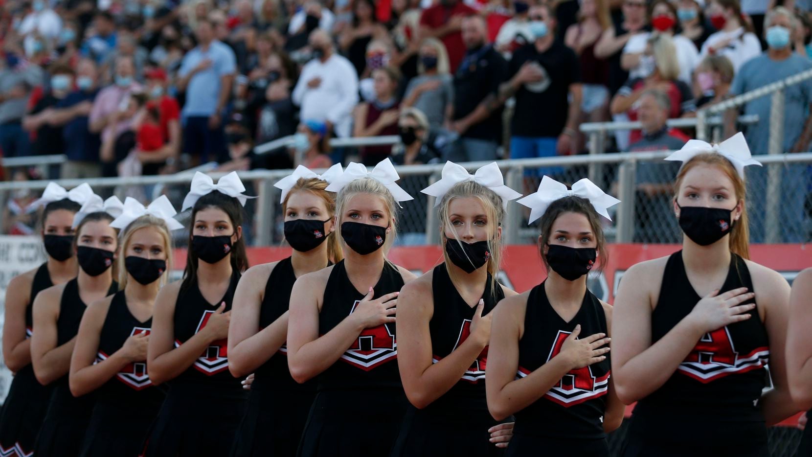 The Argyle cheerleaders and fans stand for the National Anthem during a high school football game against Decatur, in Argyle, Tx, on August 28, 2020. (Michael Ainsworth/Special Contributor)