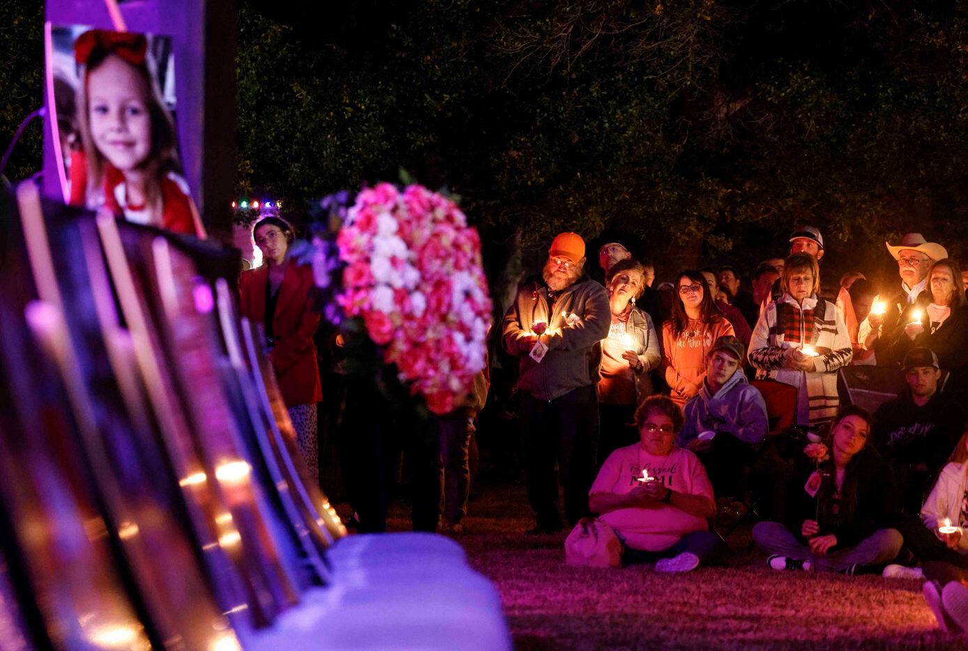Attendees hold their candles during a memorial service for late Athena Strand at First...
