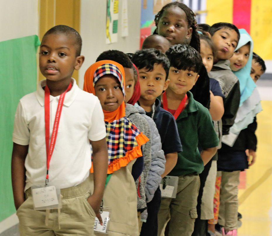 Kim Hakiza leads the line of Adrian Rivera's kindergarten class as they wait in the hallway...