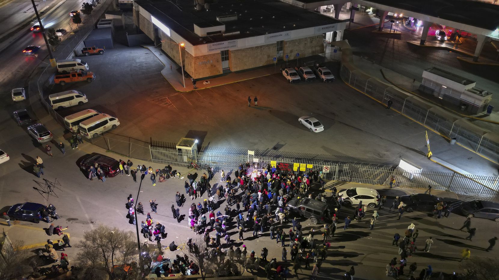People take part in a vigil for the victims of a fire at an immigration detention center...