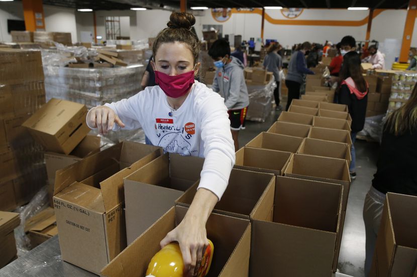 Volunteer Heather Rey of Plano works on filling boxes for a food distribution at North Texas...