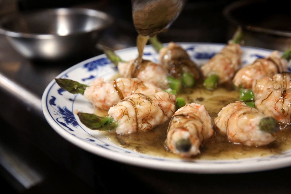 Chef Hsiu Fu "Allen" Hsu pours sauce onto shrimp-wrapped asparagus, a special banquet dish...