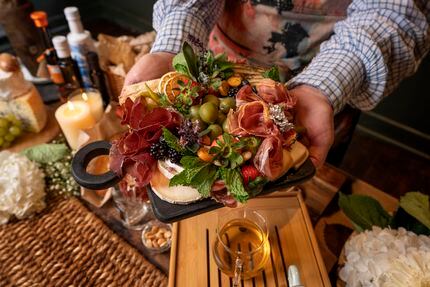 Olivia Genthe, owner of Fount Board and Table, displays a charcuterie board in the dining...