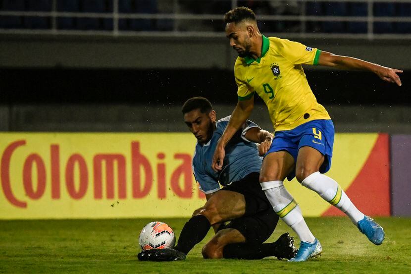 El defensa de la selección Sub-23 de Uruguay, Sebastian Cáceres (izq), pelea el balón con un...